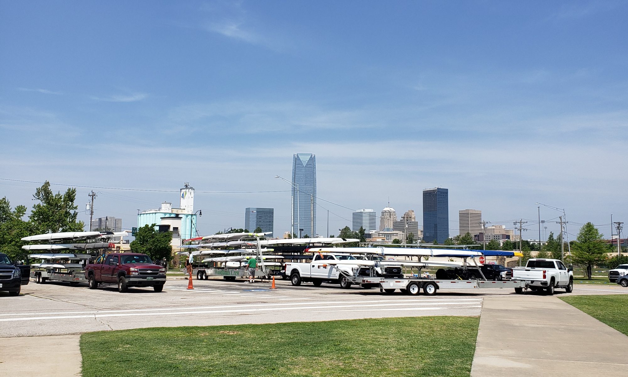 The OKC skyline forms a backdrop for a line of parked racing boat trailers.